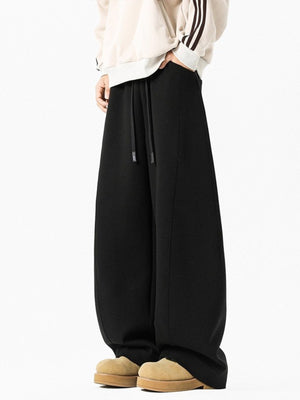 Men's black wide leg sweatpants with drawstring waist and relaxed fit.