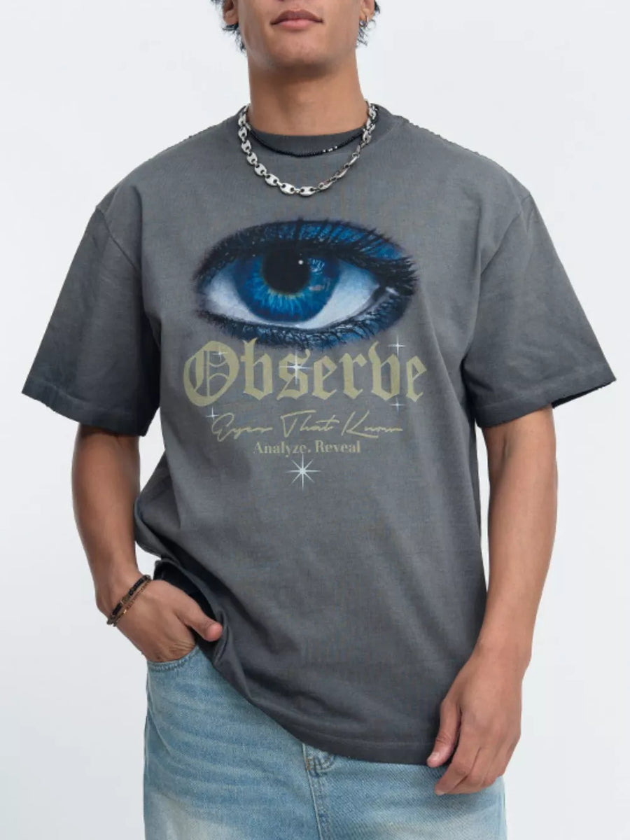 Grey graphic t-shirt with blue eye and text print, crew neck, short sleeves.
