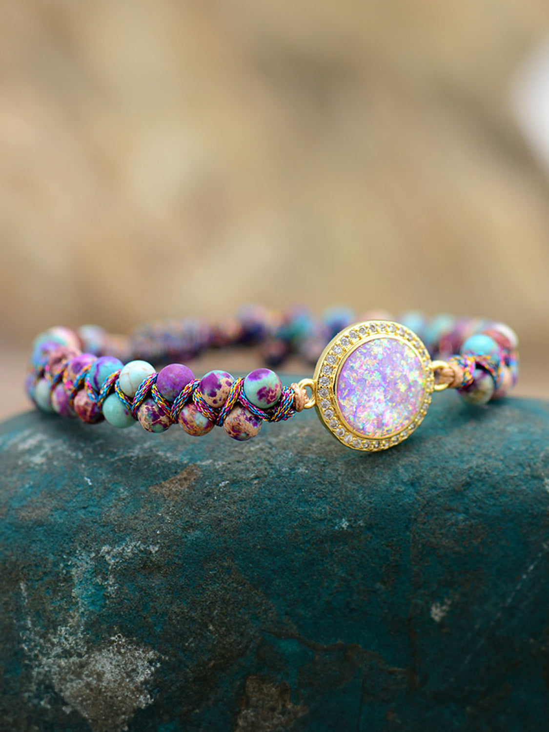 Multicolor beaded bracelet with iridescent orb and jasperite beads, gold accent.