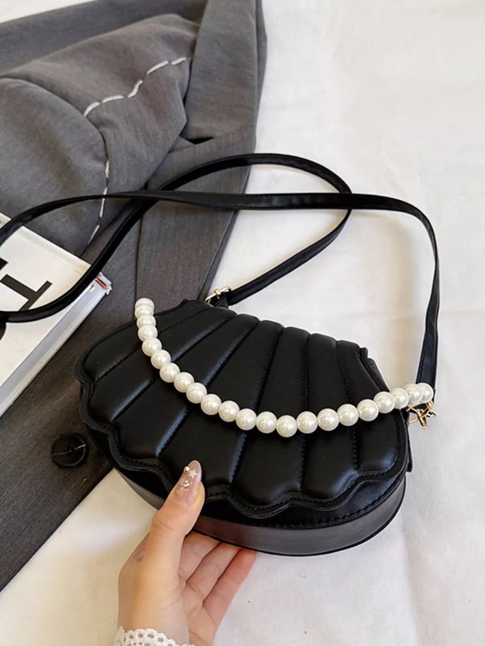 Black shell crossbody bag with pearl embellishment and quilted detail