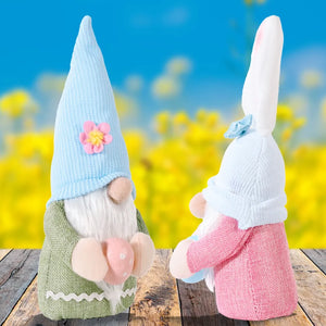 Bunny ear knit gnomes in pink and sage green holding Easter eggs.