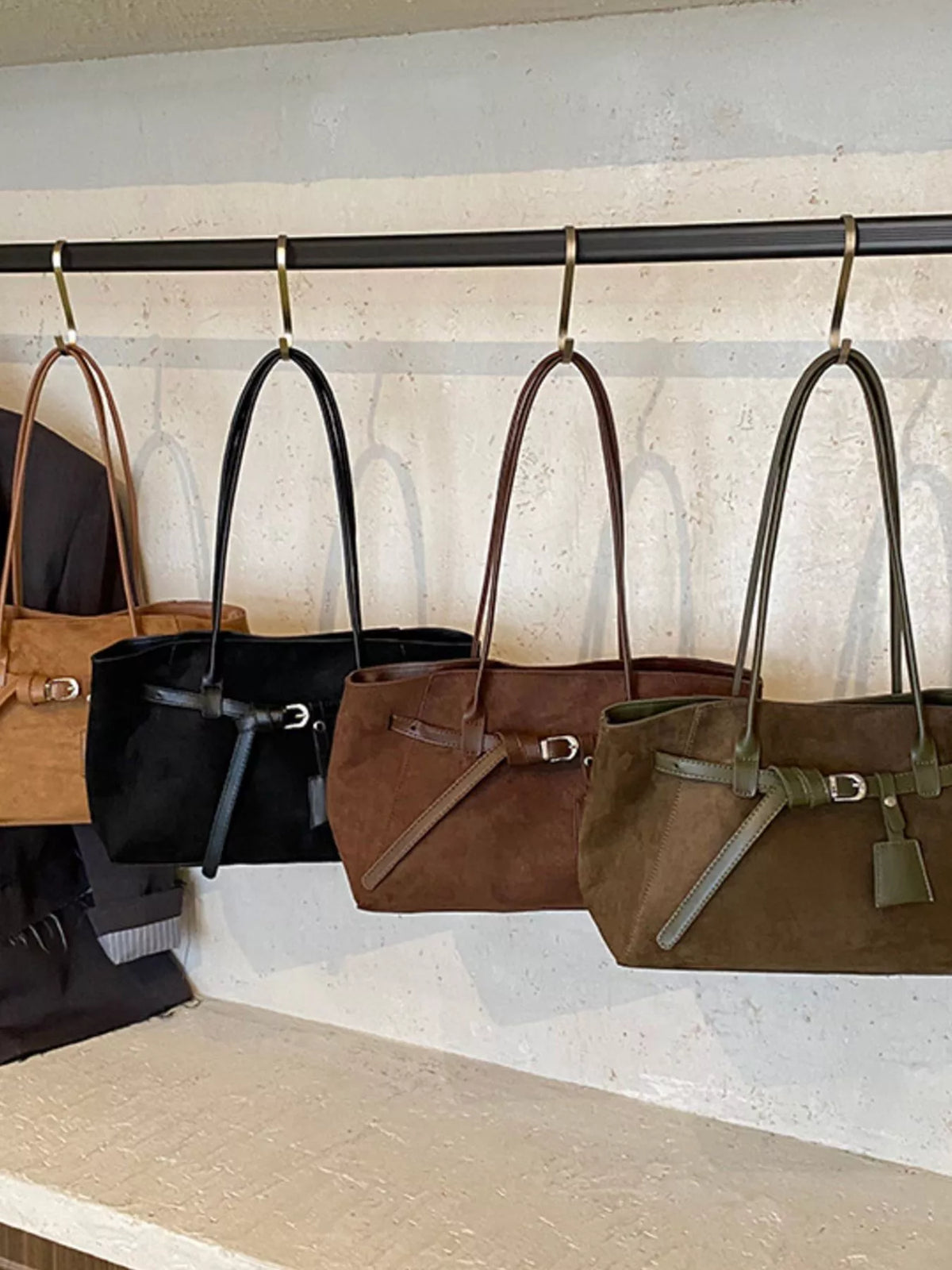 Women's suede shoulder bags in black, brown, and green with buckle detail