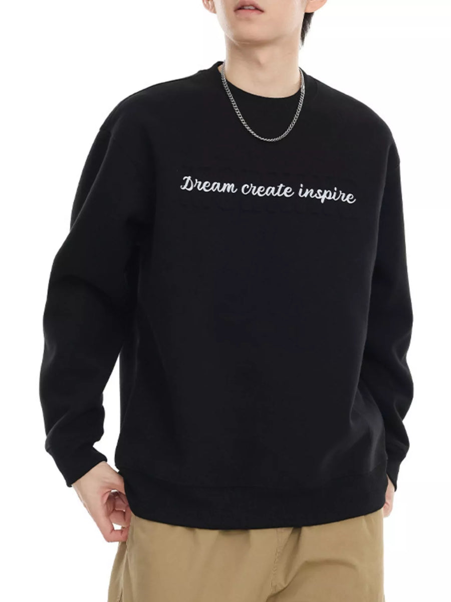 Black oversized crew-neck sweatshirt with white embroidered text "Dream create inspire