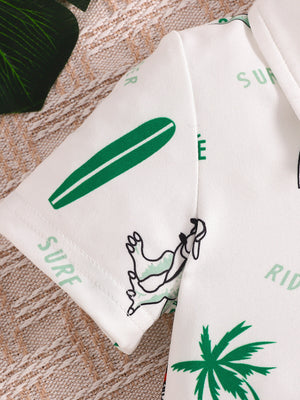 Baby polo shirt with white fabric, green dinosaur, surfboard, and palm tree print.