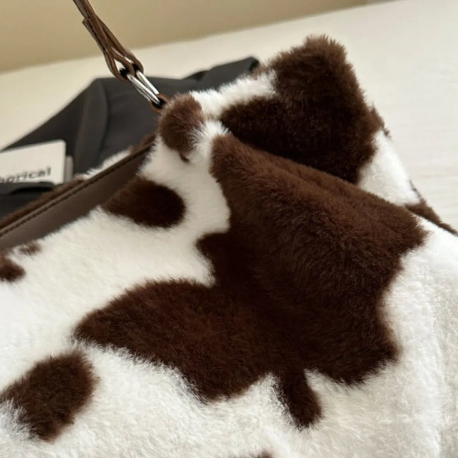 Cowhide print faux fur shopper bag in chocolate brown and white with faux leather strap detail.