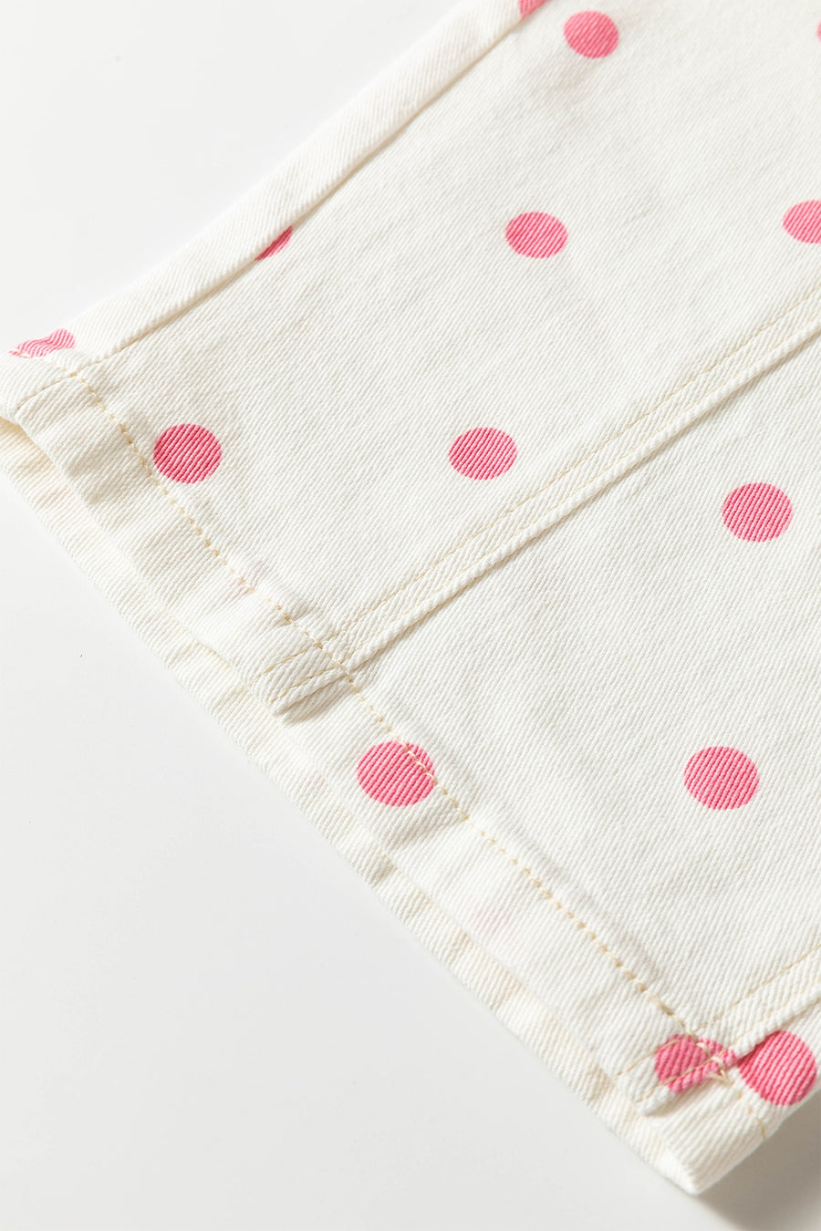 light pink wide-leg jeans with button-front and polka dot