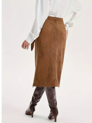 Brown midi skirt with slit detail and tie waist, styled with a white blouse and boots.