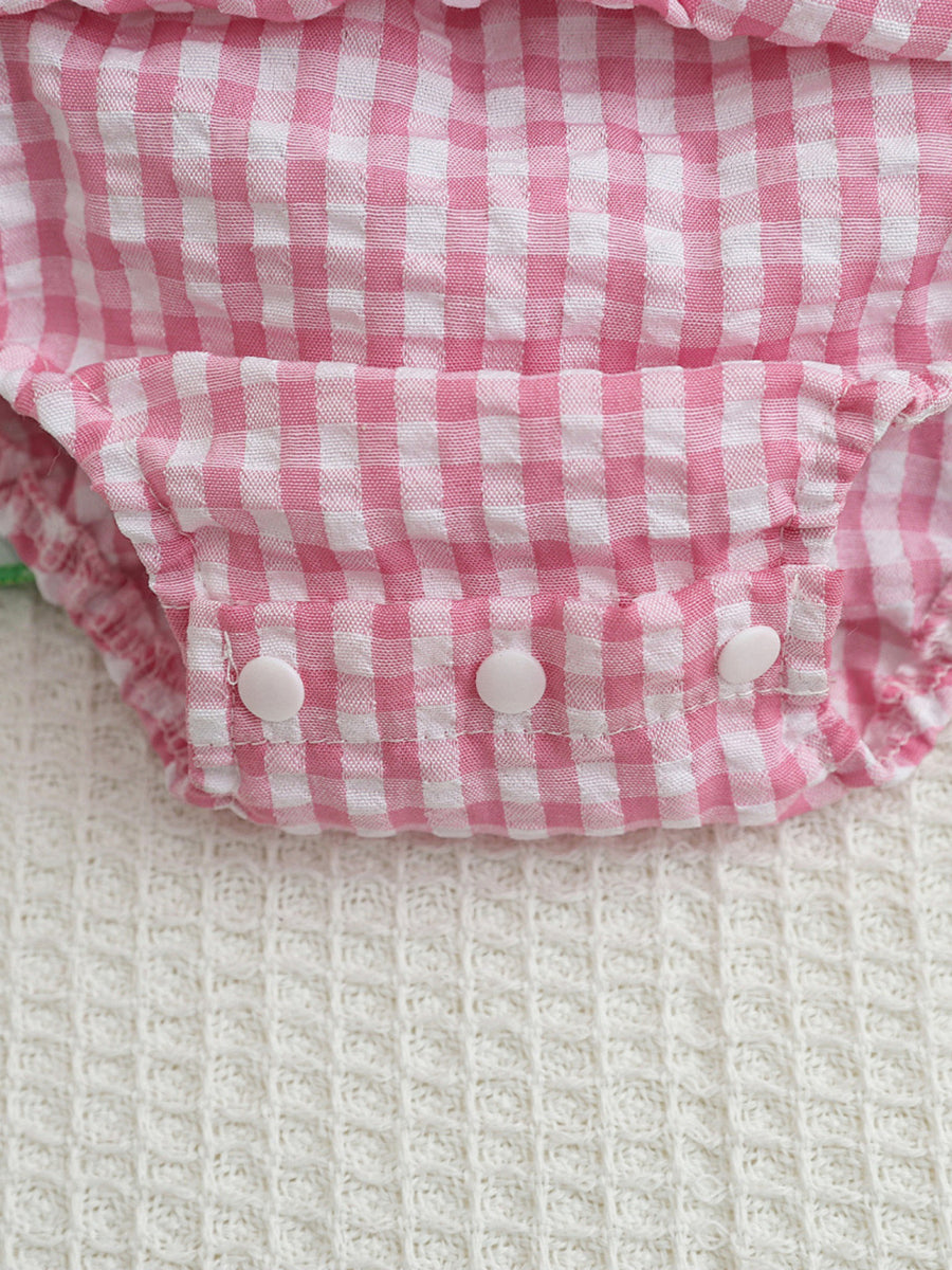 Pink gingham baby dress with smocked bodice and white button closures.