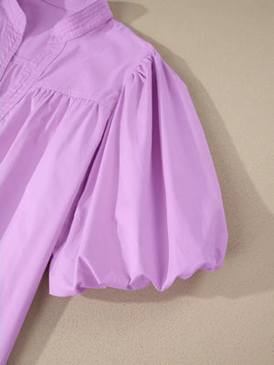 Lilac cotton shirt with notched collar and voluminous puff sleeves.