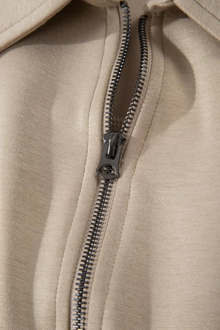 Chic collared zip front romper in beige with cap sleeves and pockets.