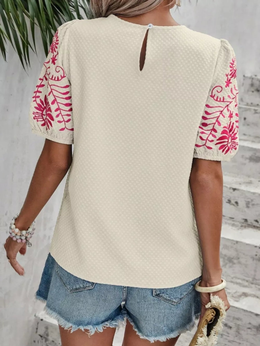 Apricot embroidered puff sleeve blouse with textured fabric and keyhole back.