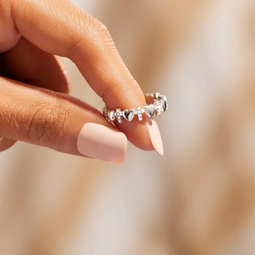 Sterling silver band ring with alternating heart and cross charms.