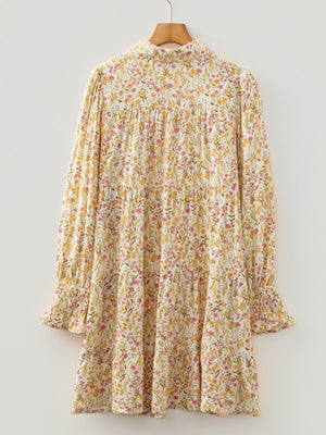 Floral print tiered shirt dress with buttoned collar and smocked cuffs.