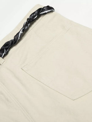 Cream white maternity pants with a black paisley print braided belt detail.