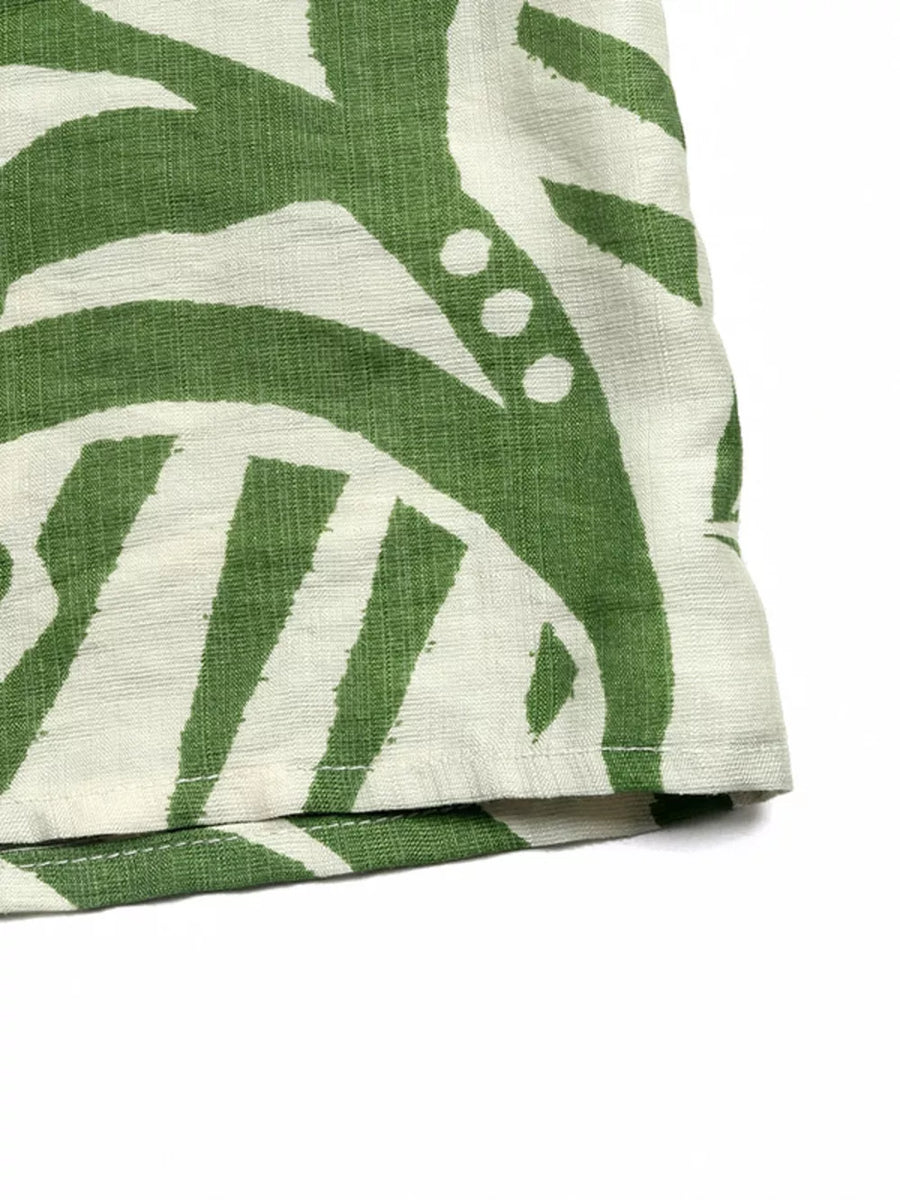Tropical tie-front strapless jumpsuit in green and white abstract print.