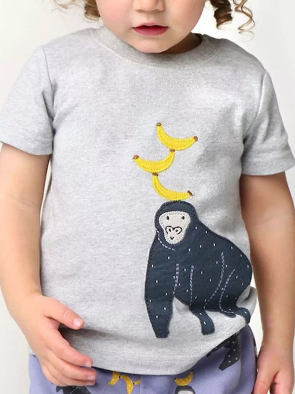 Grey t-shirt with a playful monkey and banana applique for babies and kids.