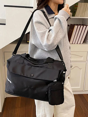 Black duffel bag with front flap, detachable pouch, and reflective stripe detail.