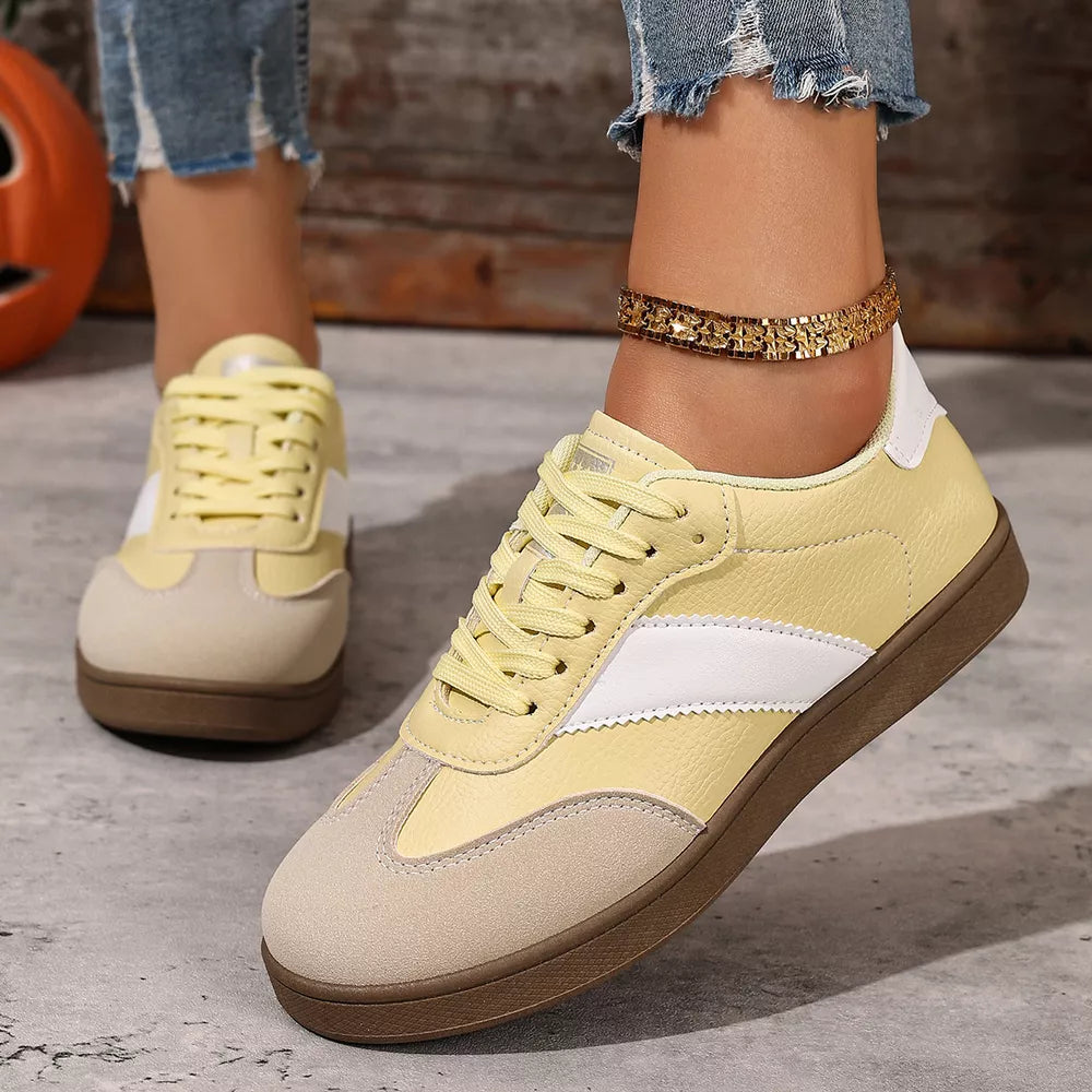 Yellow patent leather lace-up sneakers with suede accents and white stripe detail.