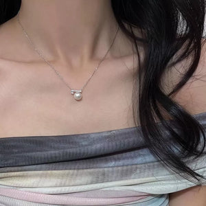 Lustrous pearl pendant necklace with zircon accents on a delicate chain.
