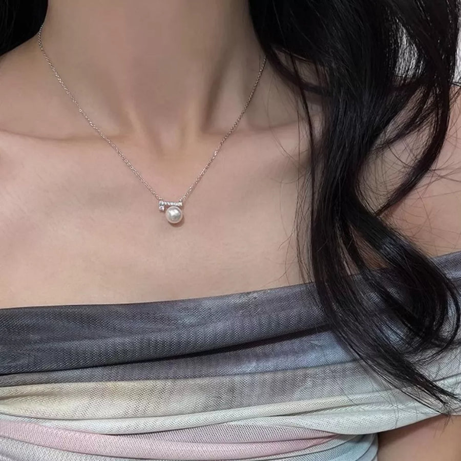 Lustrous pearl pendant necklace with zircon accents on a delicate chain.