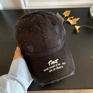 Black distressed baseball cap with white embroidered text and frayed details.