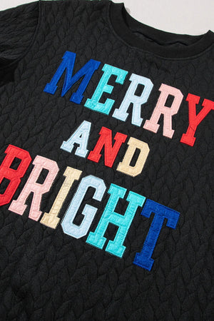 Black textured sweatshirt with "Merry and Bright" applique text in multicolor.