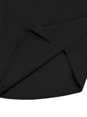 Black cotton band-collar button-down shirt detail showing hem and side slit.