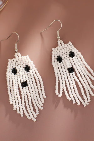 Beaded ghost fringe earrings in white with black accents and dangling fringe detail.