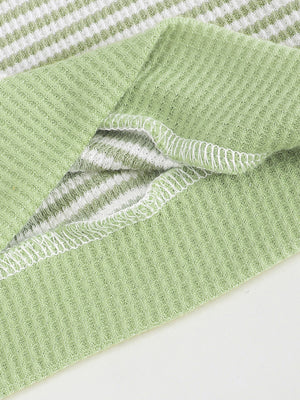 Green and white striped cotton polo shirt with waffle knit texture and white stitching detail.