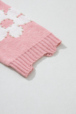 Blush pink knit sweater with pearl-embellished floral pattern and ribbed cuffs.