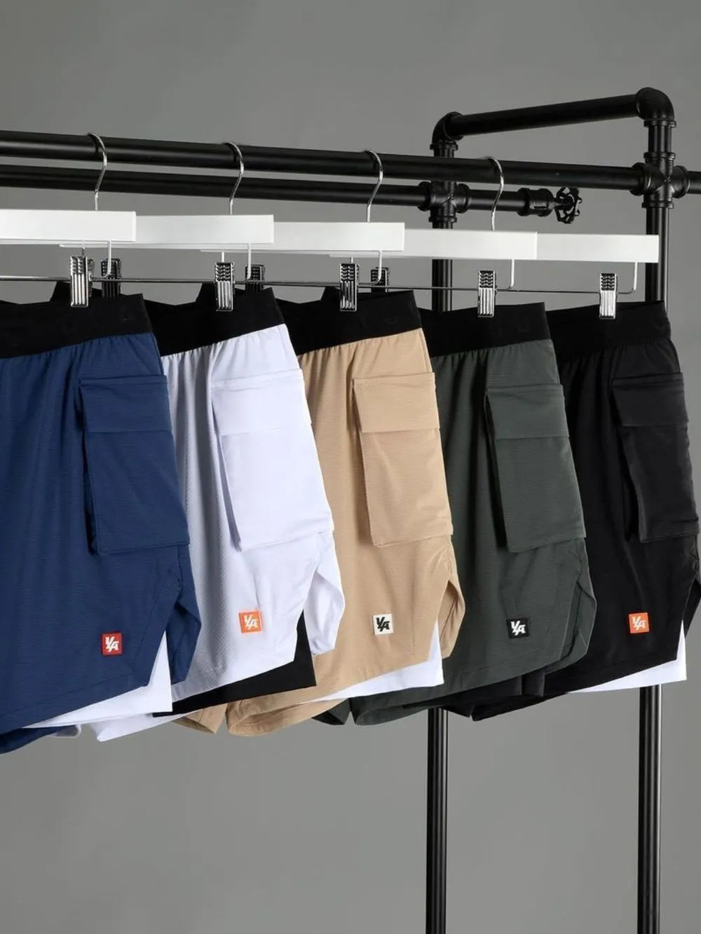 Performance layered cargo shorts in tan, white, royal blue, sage, and black with a black waistband.