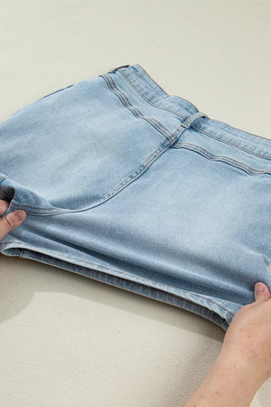 Light wash denim shorts with button fly and visible stitching detail.