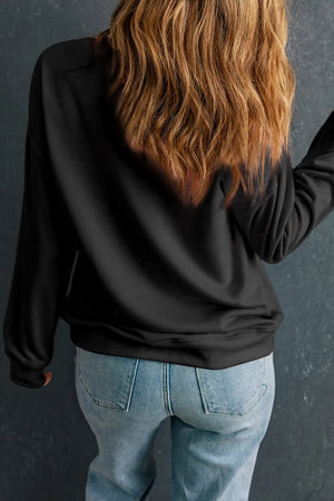 Black crewneck sweatshirt with long sleeves, casual fit, styled with jeans.