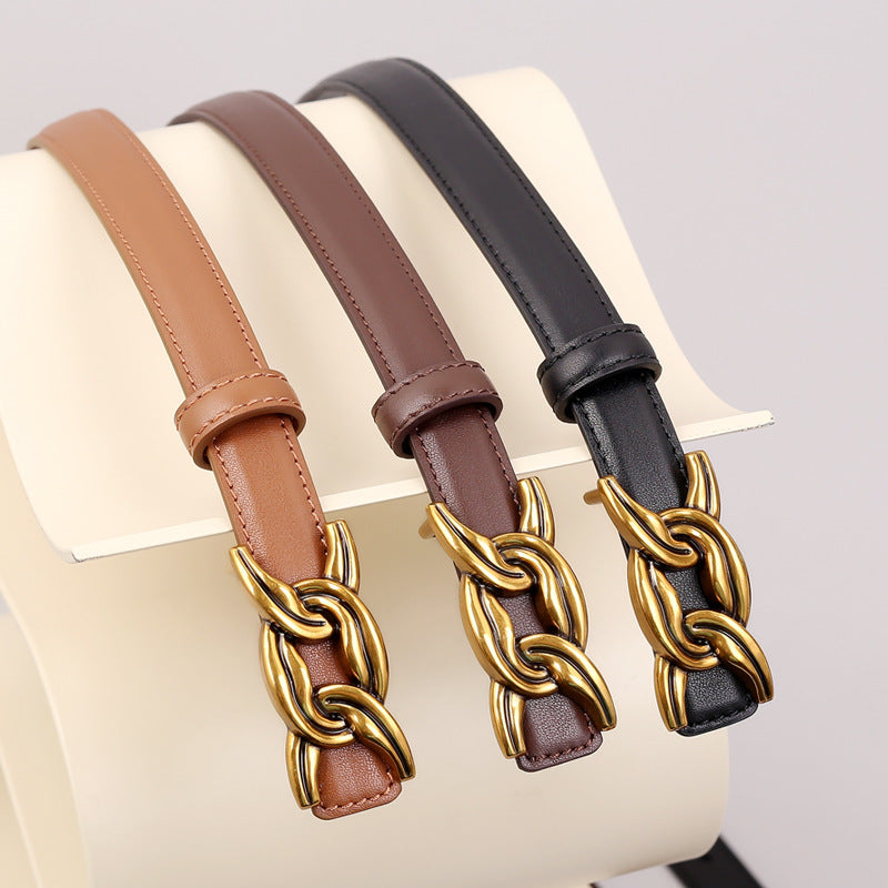 Elegant cowhide leather belts in caramel, brown, and black with gold chain buckle detail.