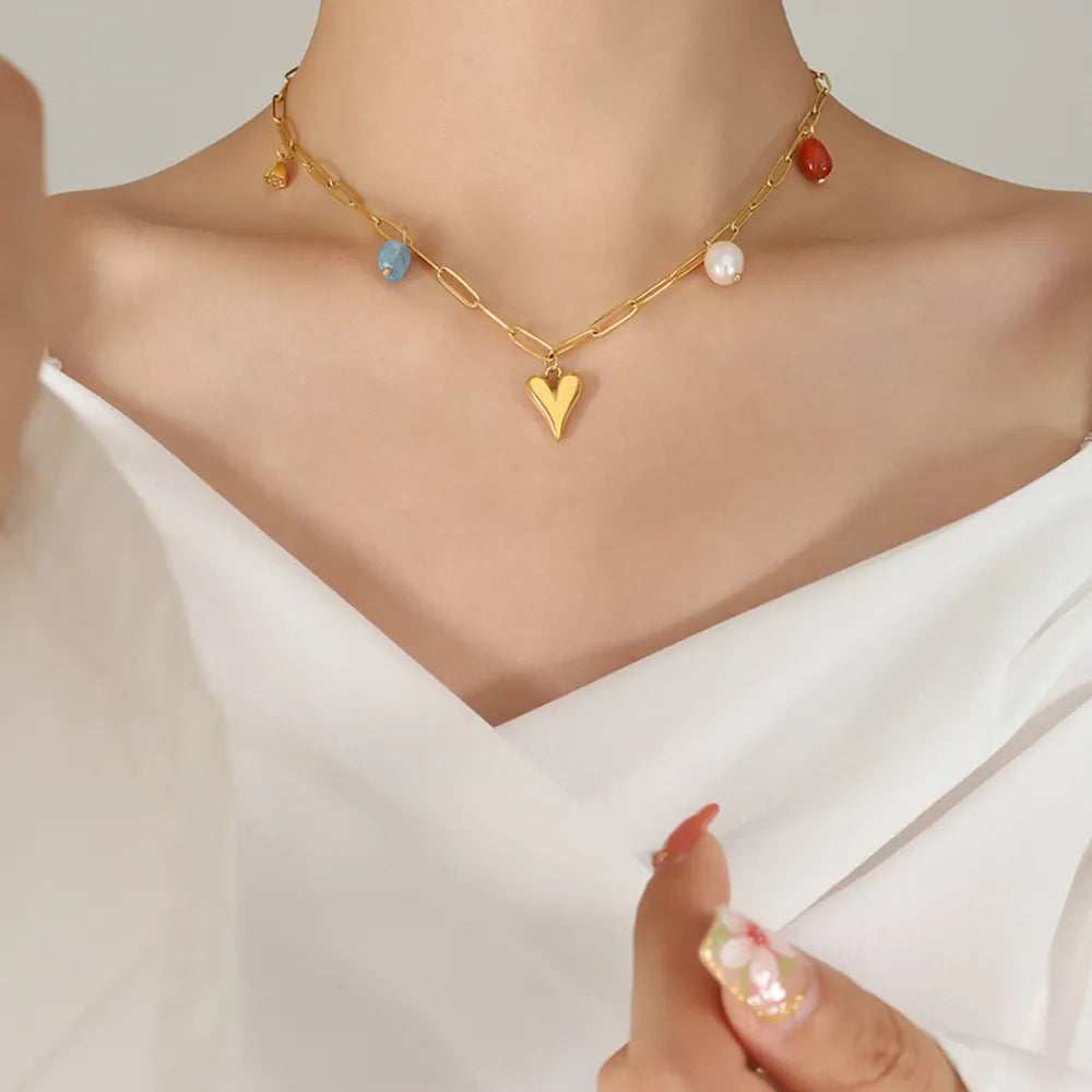 Gold paperclip chain necklace with heart charm and colorful bead accents