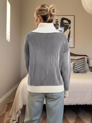 Striped knit sweater in black and white with a contrast white collar and hem.