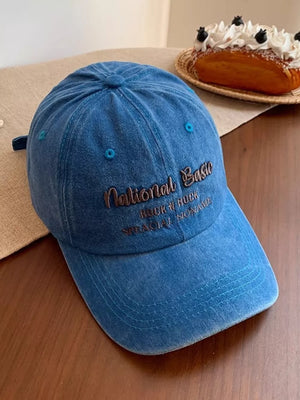 Blue washed baseball cap with embroidered text detail
