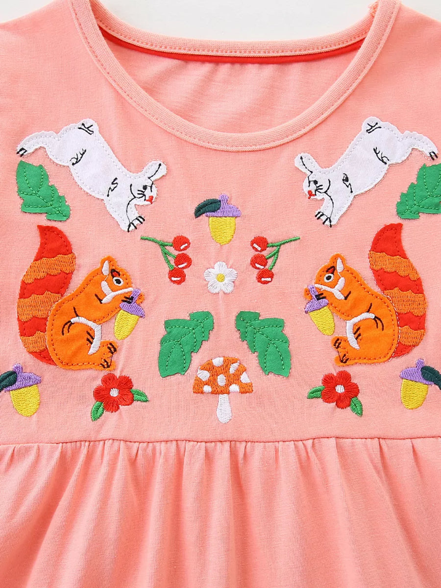 Toddler peach cotton dress with playful squirrel and rabbit embroidery, acorns, mushrooms, and cherries.
