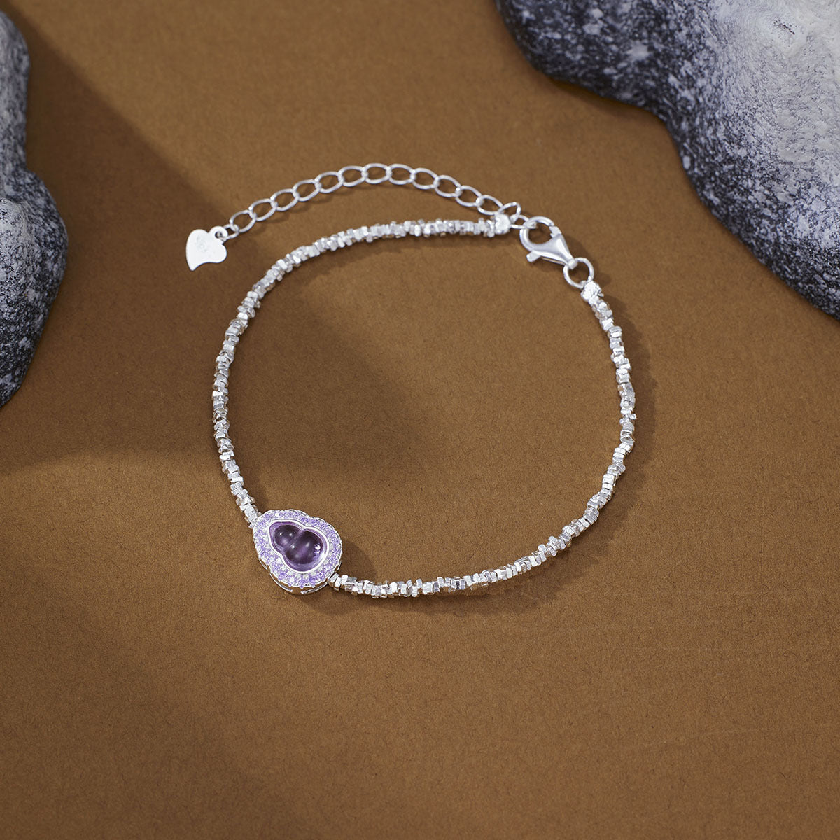 Delicate silver charm bracelet with purple gourd charm and crystal accents.