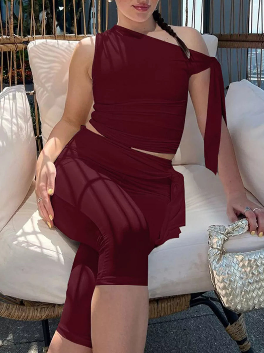 Burgundy asymmetrical one-shoulder top with tie detail and capri pants set.