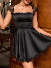 Black lace-embellished square neck mini dress with cap sleeves and ruffled bodice.