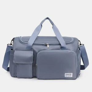 Duffel bag in Dusty Blue with multiple utility pockets and adjustable strap.