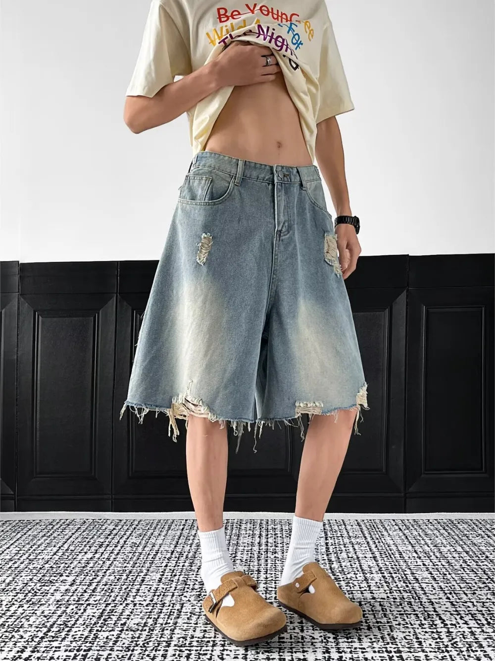 Light-wash denim shorts with distressed details and raw hem.