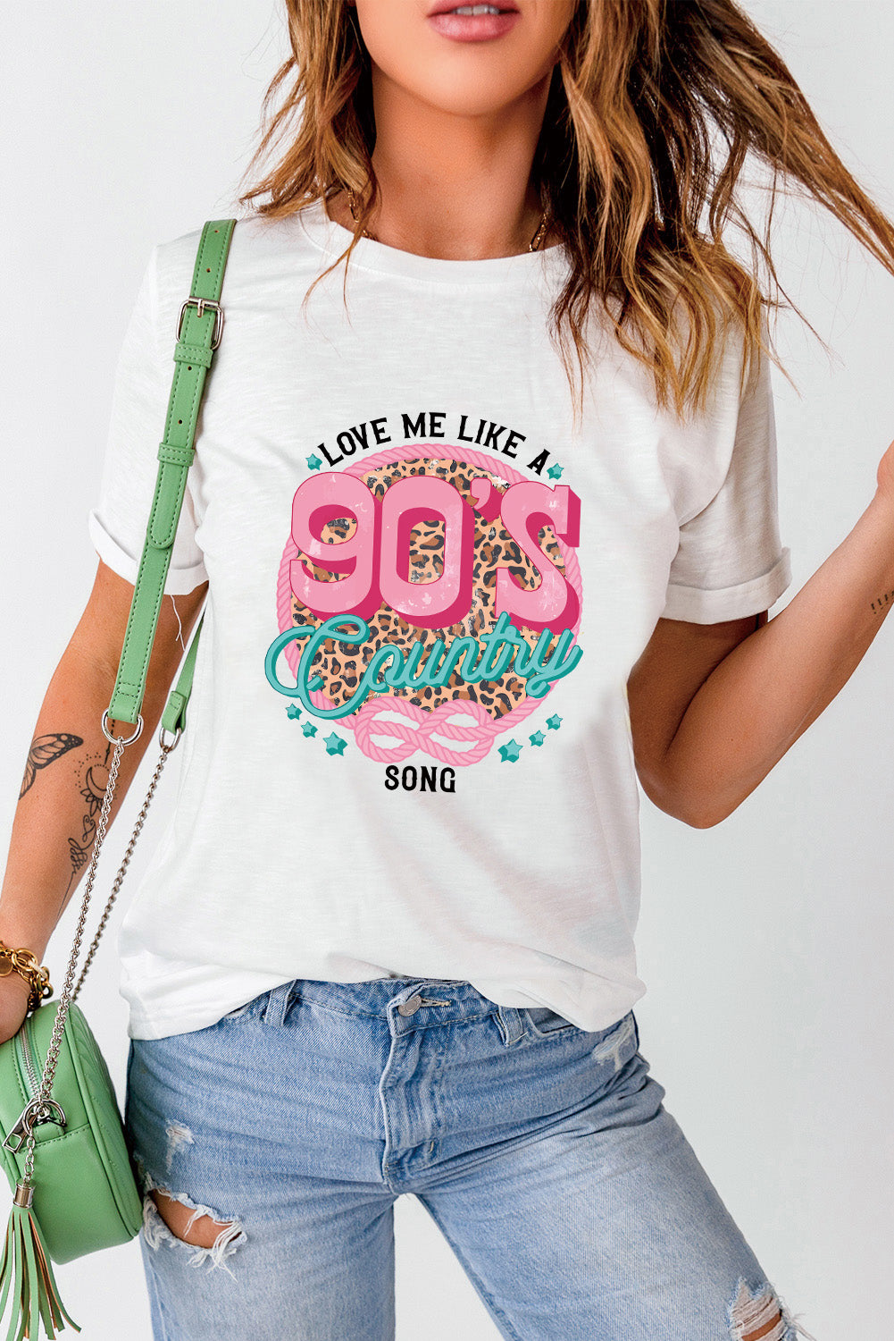 White graphic t-shirt with 90s country song design and leopard print detail.