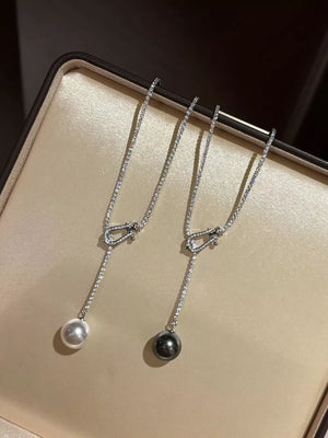 Lustrous pearl drop Y-necklace in dark gray and eggshell with delicate crystal chain.