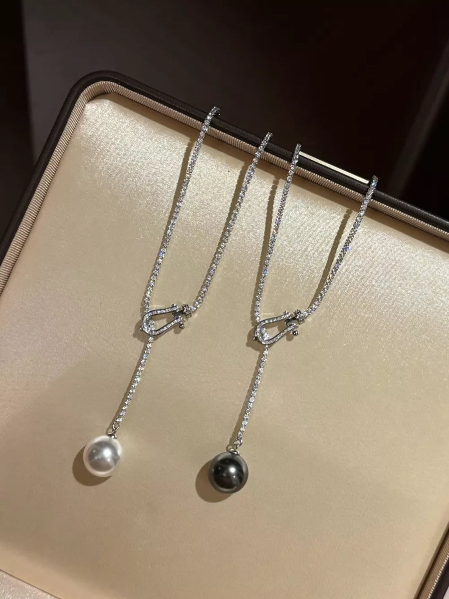 Lustrous pearl drop Y-necklace in dark gray and eggshell with delicate crystal chain.