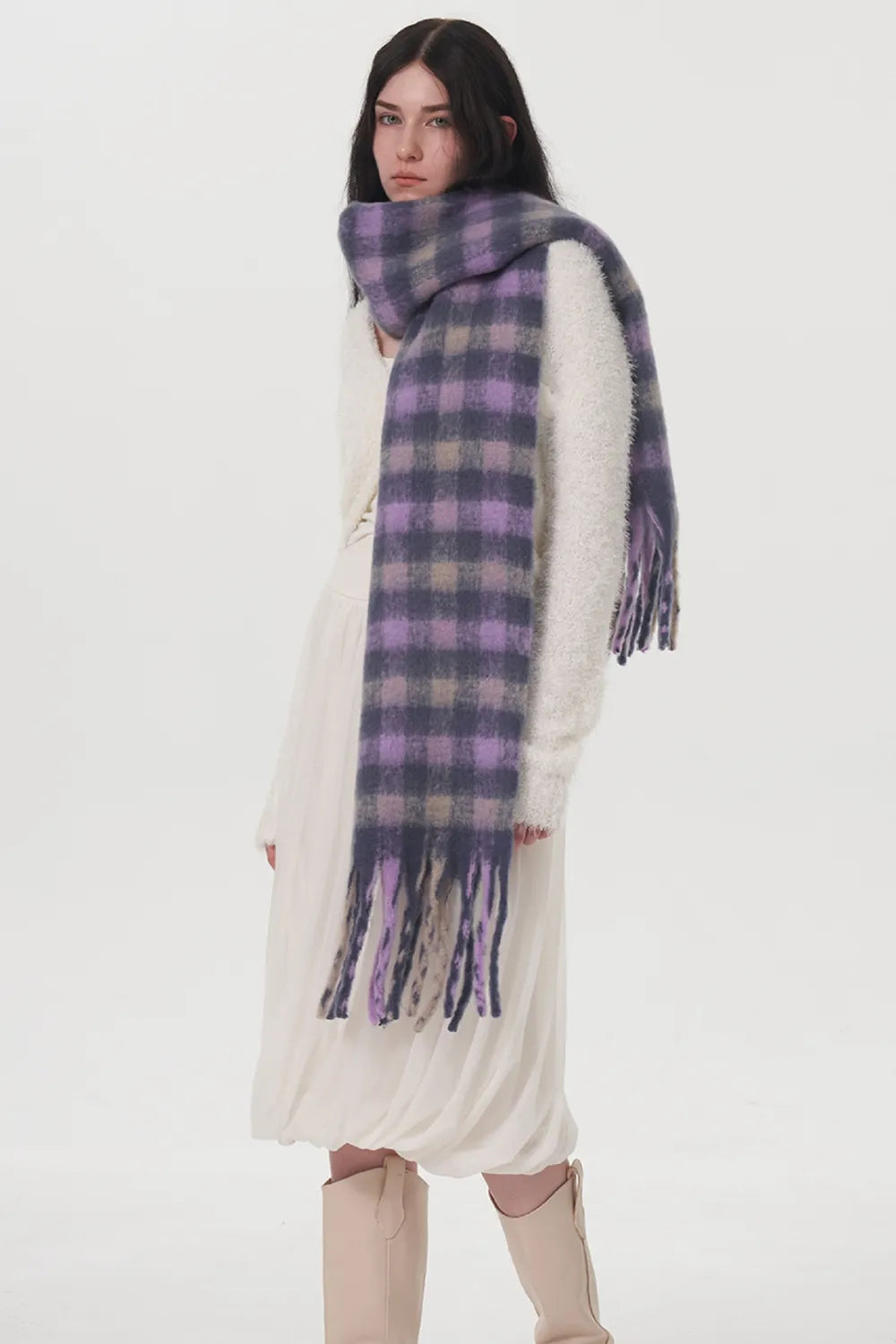 Plush lilac checkered scarf with fringe detail, worn by a woman.