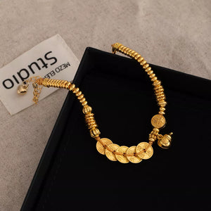 Gold bracelet featuring coin charms and character print
