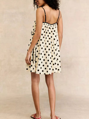 Cream polka dot mini dress with black trim and spaghetti straps