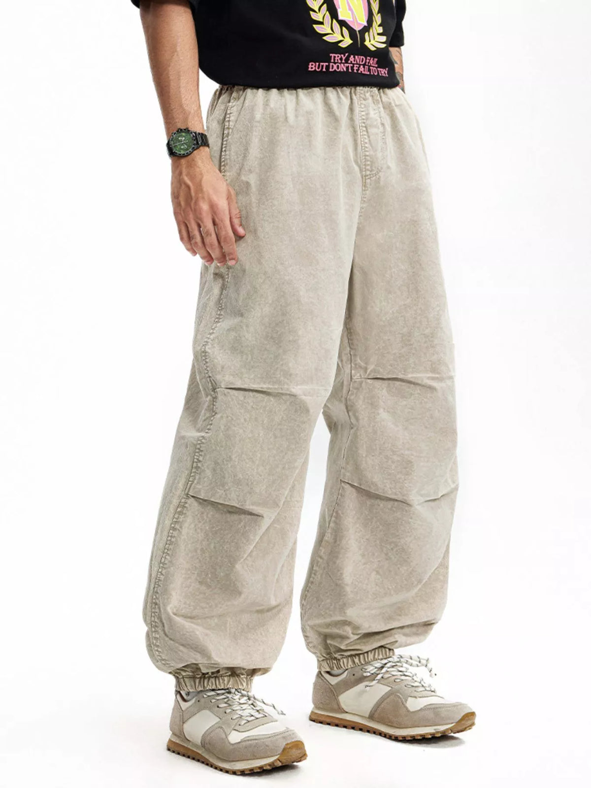 Khaki relaxed fit cargo pants with elastic waistband and cuffs, featuring paneled legs.